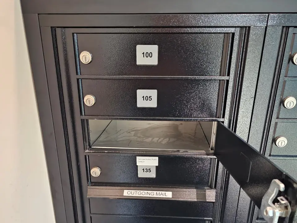 A bank of black lock-box mailboxes with one compartment door open
