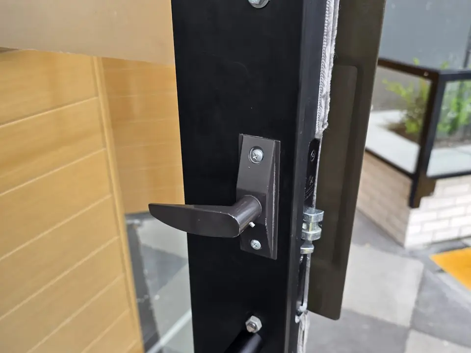Black storefront door with a lever handle and latch hardware