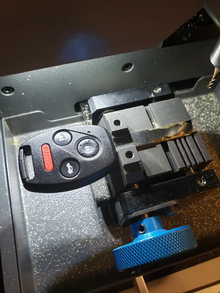 Car key fob clamped in a key cutting machine